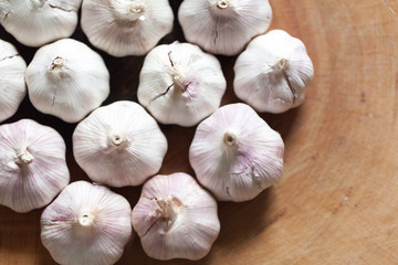 a clove of garlic and a whole wooden table closeup