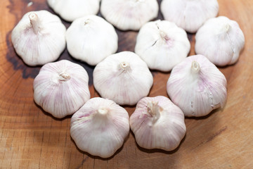 a clove of garlic and a whole wooden table closeup