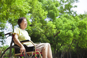 Obraz premium Asian senior woman sitting on a wheelchair in the park