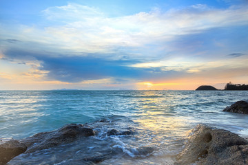 Fototapeta na wymiar Panoramic dramatic tropical sunset sky and sea with rock surface