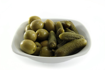 Saucer of olives and gherkins isolated on white