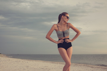 Fototapeta na wymiar VINTAGE STYLED model posing at the beach