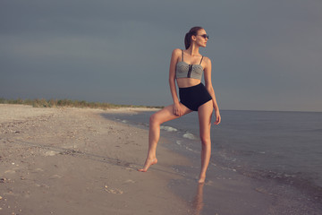 Fototapeta na wymiar fashionable female model posing at the beach