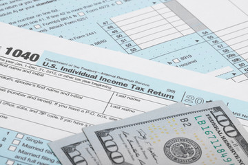 USA 1040 Tax Form with two 100 US dollar bills