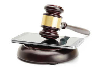 Smartphone under judge gavel isolated on white background