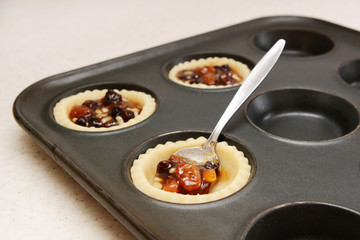 Spooning mincemeat into pastry cases