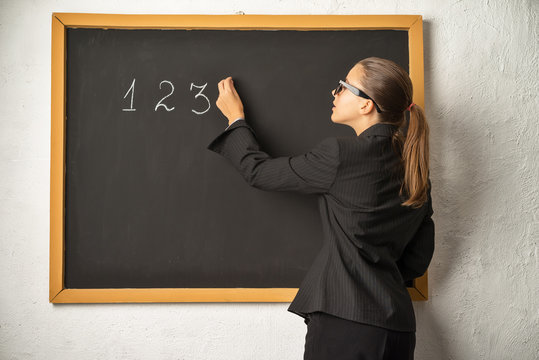 Teacher near blackboard. Math lesson.