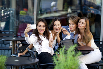 Four women sitting in a cafe on the street