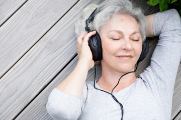 Seniorin mit Kopfhörern genießt Musik