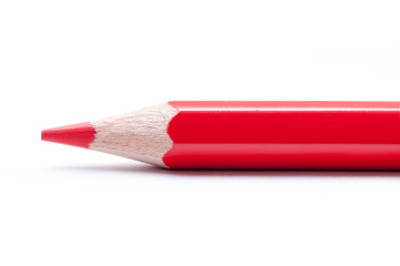 Red pencil on white background. Macro.
