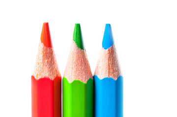 Red, green and blue pencils on white background. Macro.