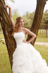 Fototapeta na wymiar Beautiful bride with stylish make-up in white dress