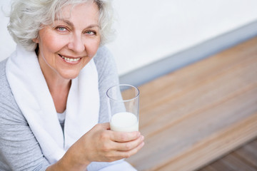 Seniorin mit einem Glas Milch