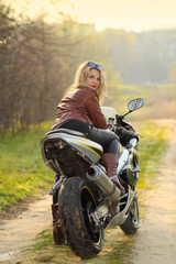 Fototapeta na wymiar Portrait of attractive girl on sports bike. 