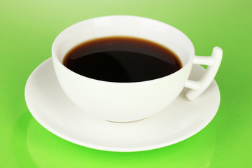 A cup of strong coffee on green background
