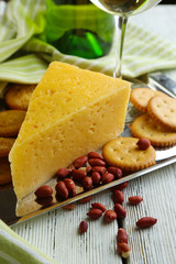 Wine, cheese and crackers on wooden table close-up