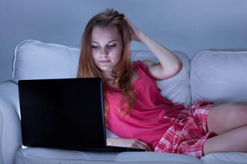 Girl in pajamas using laptop