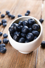 Delicious blueberries in bowl on table close-up