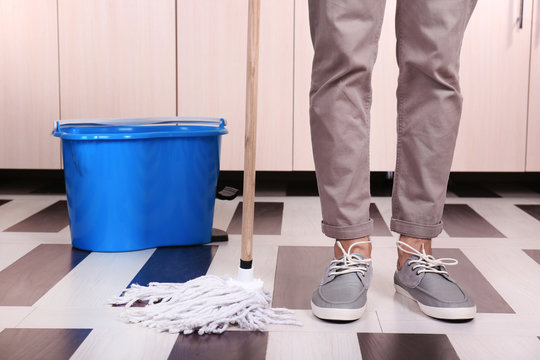 Young Man Cleaning Floor In Room