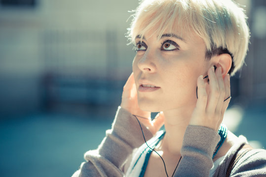 beautiful young blonde short hair hipster woman listening music
