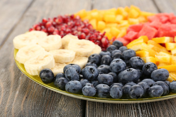 Sliced fruits on plate on wooden table