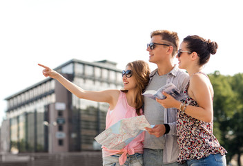 smiling friends with map and city guide outdoors