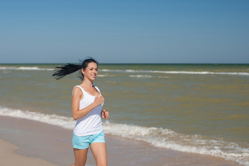 Fototapeta na wymiar Young girl runs on the sea