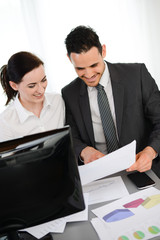 business people analysing company results paperwork and computer