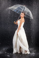 Bride under rain with umbrella