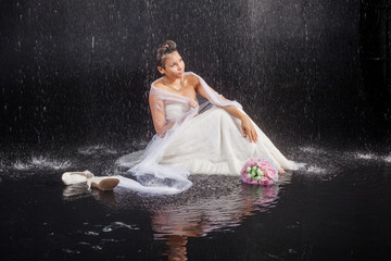 girl in white dress lays in water studio