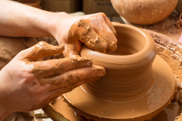 hands of a potter, creating an earthen jar