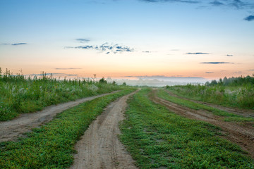 Fototapeta na wymiar summer landscape with sunrise, fog and the road