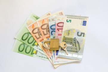 Euro Geldscheine mit Vorhaengeschloss und Schluessel auf weiss