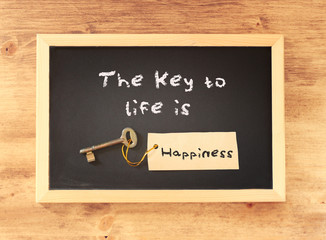 the phrase the key to life is happiness written on blackboard
