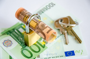 Euro gerollt mit Schloss und Schluessel auf Banknoten
