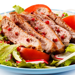 Grilled meat and vegetables on white background