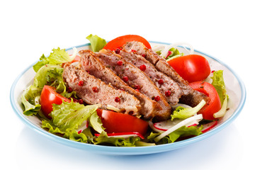 Grilled meat and vegetables on white background