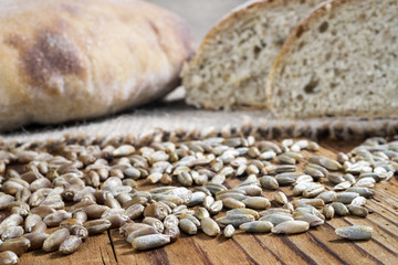 wheat, rye and bread on wooden table, selective focus
