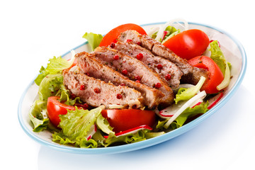 Grilled meat and vegetables on white background