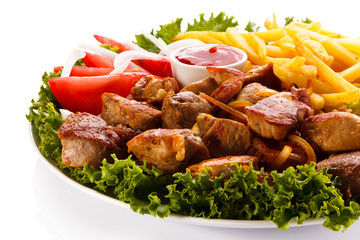 Grilled meat with French fries and vegetables