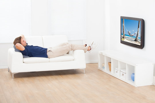 Man Watching Beach View On TV At Home