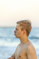 handsome teenager at the beach in sunset