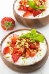 dessert of yogurt with fresh strawberries, pistachios and mint