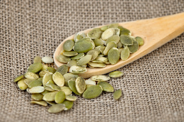 Pumpkin seeds in a wooden spoon.