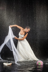 Bride sitting under rain