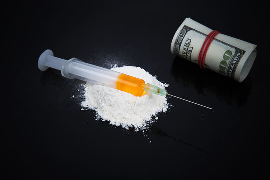 Cocaine drugs heap with syringe and dollars