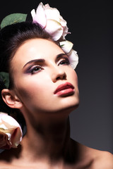 Naklejka premium Closeup portrait of beautiful young woman with pink flowers in h
