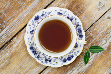 Tea in vintage cup on wooden surface