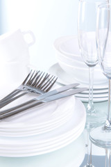 Set of white dishes on table on light background