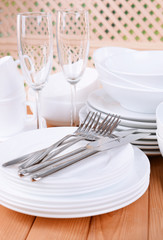 Set of white dishes on table on light background